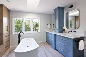 A contemporary modern bathroom design. featuring a contemporary classic freestanding porcelain bathtub against a scenic window.