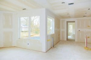 Interior construction of housing project with drywall installed and patched without painting applied interior with drywall installation and construction work in progress