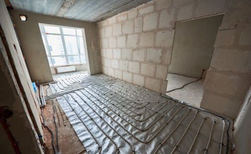 Comparative image of a room - before and after repairs. Unfinished empty walls, doorway, floor heating system vs shiny tiled floor, plastered walls, white new door. Renovation concept