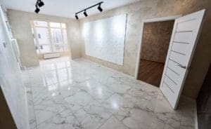 Comparative image of a room - before and after repairs. Unfinished empty walls, doorway, floor heating system vs shiny tiled floor, plastered walls, white new door. Renovation concept